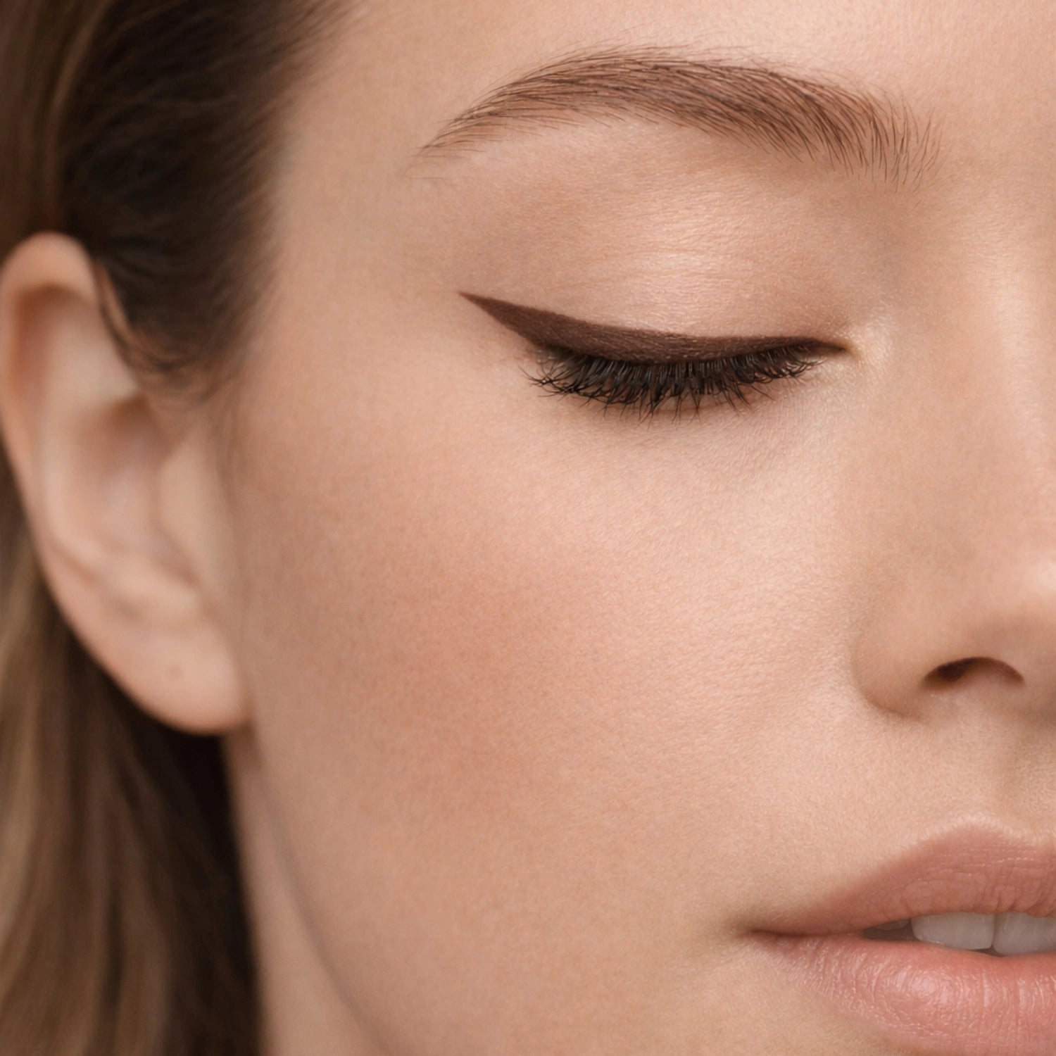 Close-up of eyelid with smooth, precise brown automatic eye pencil finish